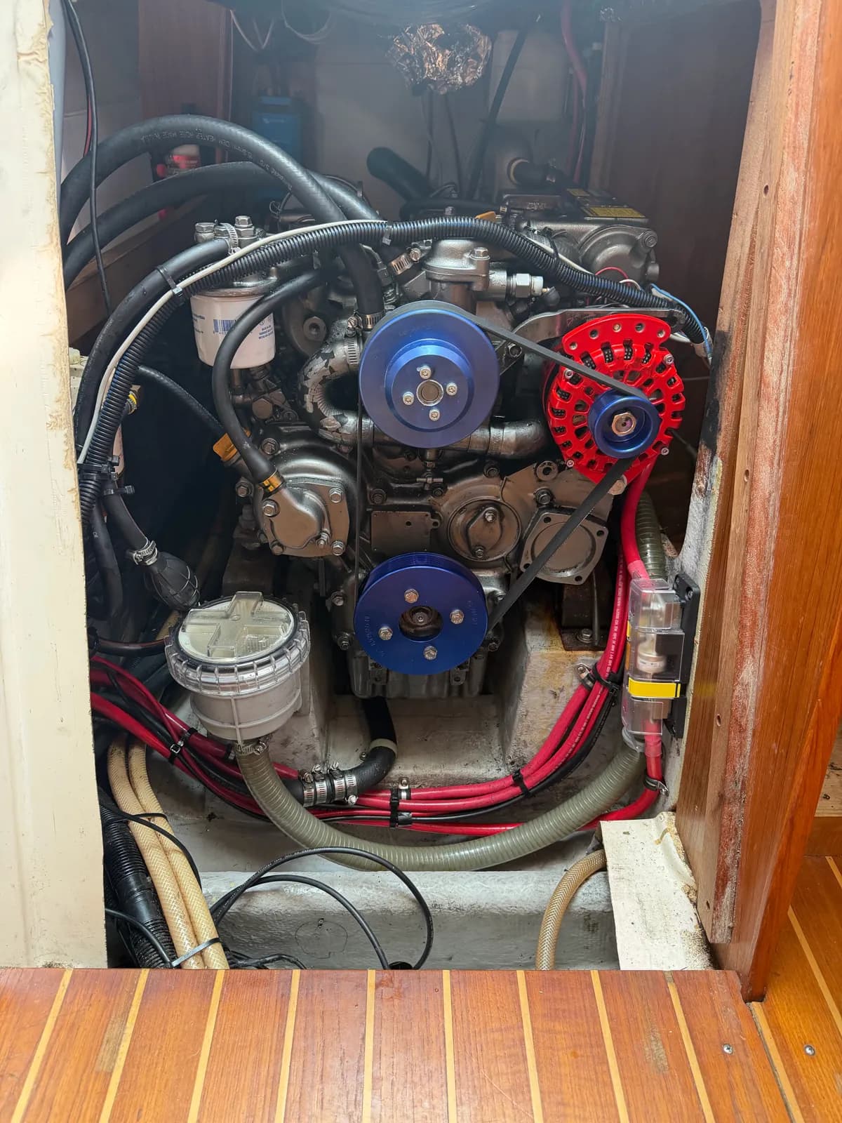 Marine diesel with an upgraded high-output alternator and billet pulleys for charging a lithium house bank.